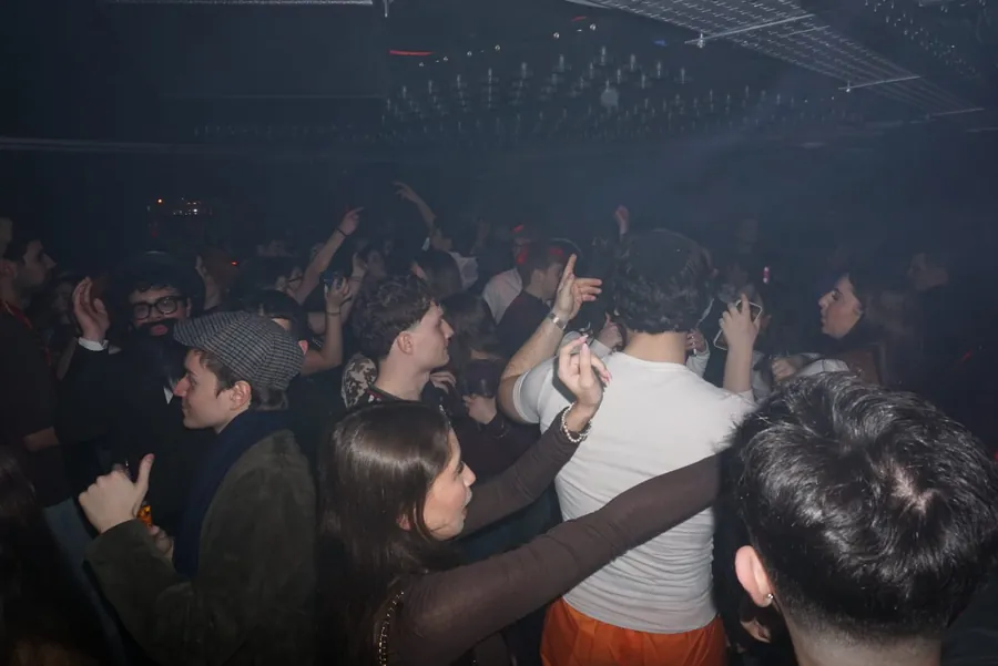 Crowd with hands up under blue light